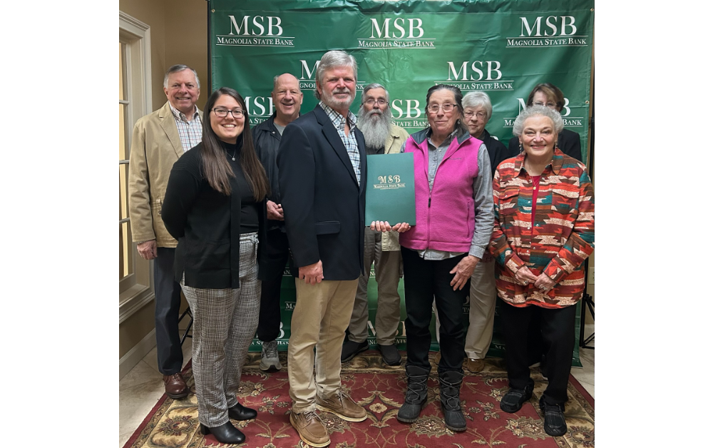 Members of Magnolia State Bank handing off deed of historical property to Members of the Old Clinton Historic Society. Pictured: Back Row from Left to Right: Hall Newberry, Rick Childs, Johnny Mack, Deloras Moon, Barbara Fordham. Front Row: Catelynn Duncan, Mell Merritt, Earlene Hamilton, Lindsey Hamrick.