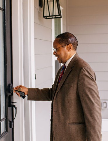 man unlocking door to his home.